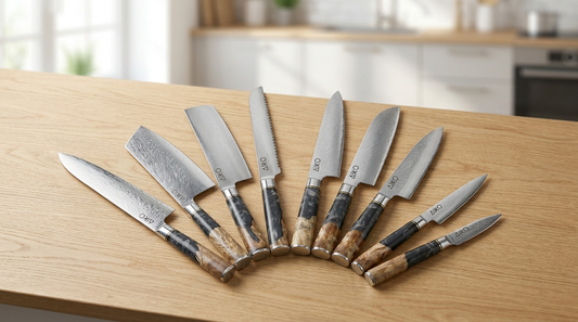 Japanese Damascus steel knives fanned across a warm light-oak kitchen worktop